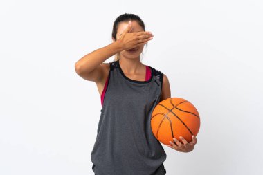 İzole edilmiş beyaz arka planda basketbol oynayan genç İspanyol kadın elleriyle gözlerini kapatıyor. Bir şey görmek istemiyorum.