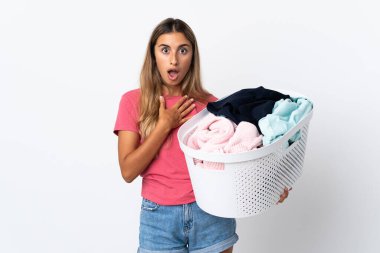 Beyaz arka planda izole edilmiş çamaşır sepetini tutan genç bir kadın sağa bakarken şaşırmış ve şok olmuştu.