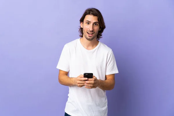 Joven Hombre Guapo Aislado Sobre Fondo Púrpura Sorprendido Enviando Mensaje —  Fotos de Stock