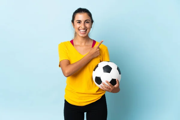 Joven Futbolista Hispana Aislada Sobre Fondo Azul Apuntando Hacia Lado — Foto de Stock