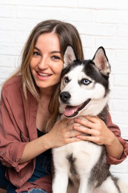 Genç ve güzel bir kadın. İri köpeğiyle içeride yerde oturuyor.