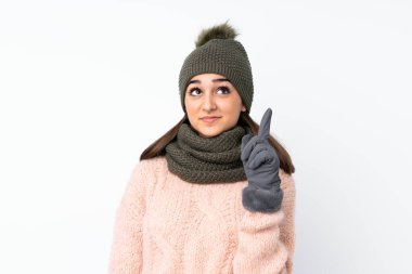 Kışlık şapkalı genç kız izole edilmiş beyaz arka planda işaret parmağıyla işaret etmek harika bir fikir.