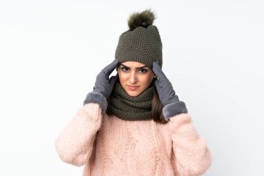 Kışlık şapkalı genç kız izole edilmiş beyaz arka planda mutsuz ve hayal kırıklığına uğramış. Olumsuz yüz ifadesi