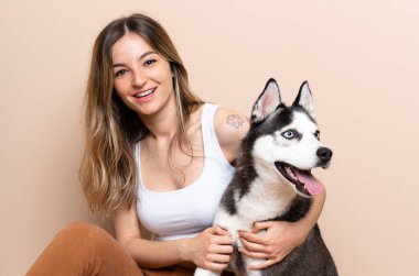 Genç ve güzel bir kadın. İri köpeğiyle içeride yerde oturuyor.