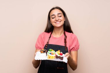 Elinde mini pastalarla izole edilmiş genç bir kadın.