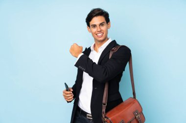 İzole edilmiş mavi arka planda zaferi kutlayan iş adamı.