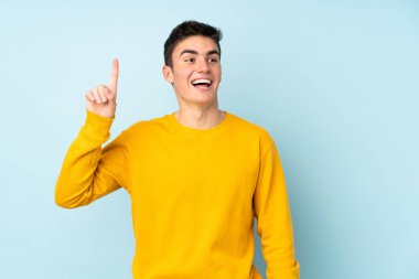 Mor arka planda izole genç beyaz yakışıklı adam çözümü bulmak için parmağını kaldırıyor.