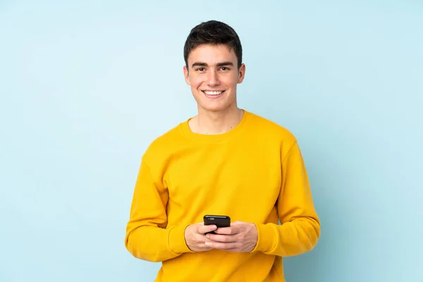 Teenager Kavkazský Pohledný Muž Izolované Fialovém Pozadí Odesílání Zprávy Mobilním — Stock fotografie