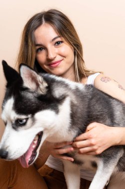 Genç ve güzel bir kadın. İri köpeğiyle içeride yerde oturuyor.