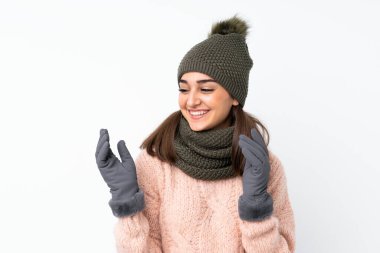 Kışlık şapkalı genç kız soyutlanmış beyaz arka planda gülüyor
