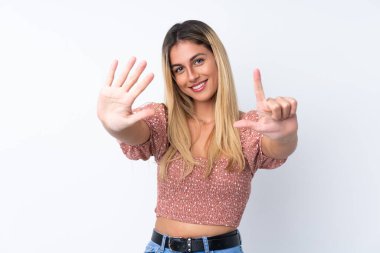 Genç Uruguaylı kadın izole edilmiş beyaz arka planda yediyi parmaklarıyla sayıyor