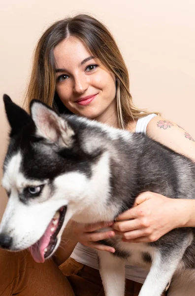 Genç ve güzel bir kadın. İri köpeğiyle içeride yerde oturuyor.