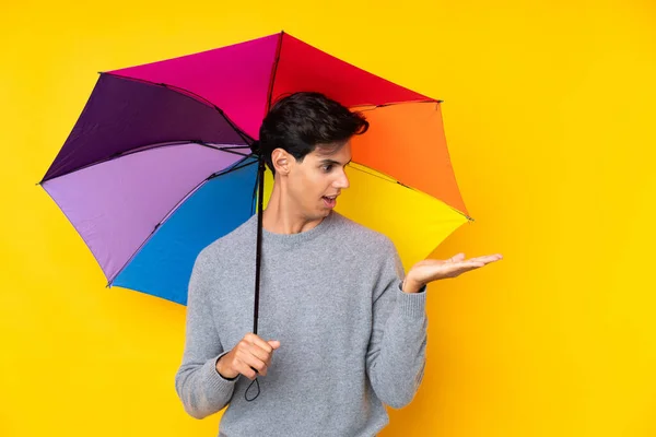 Muž Držící Deštník Nad Izolovaným Žlutým Pozadím Držící Dlani Pomyslný — Stock fotografie