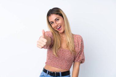 Genç Uruguaylı kadın izole edilmiş beyaz arka planda. Başparmakları havada. Çünkü iyi bir şey oldu.