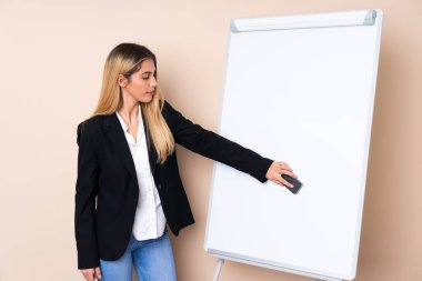 Genç Uruguaylı kadın beyaz tahtada sunum yapıyor.