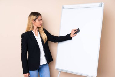 Genç Uruguaylı kadın beyaz tahtada sunum yapıyor.