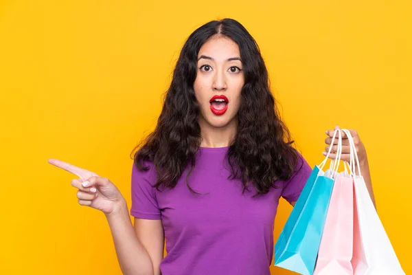 Spaanse Chinese Vrouw Met Boodschappentas Geïsoleerde Achtergrond Verrast Wijzend Kant — Stockfoto