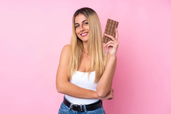 年轻的乌拉圭女人 带着巧克力片 带着快乐的心情 从孤立的粉红背景中走出来 — 图库照片