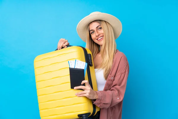 带着手提箱和护照度假的乌拉圭年轻女子 背景是孤立的蓝色 — 图库照片