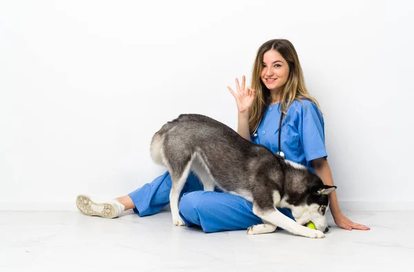 Врач Ветеринар Сибирской Собакой Хаски Сидящей Полу Показывает Знак Пальцами — стоковое фото