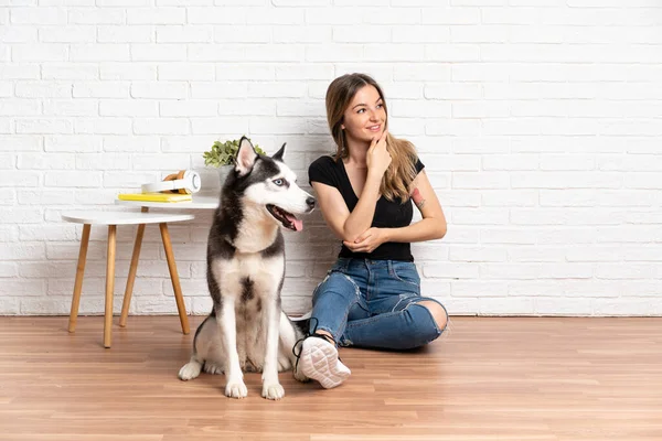 Joven Mujer Bonita Con Perro Husky Sentado Suelo Interior Mirando —  Fotos de Stock