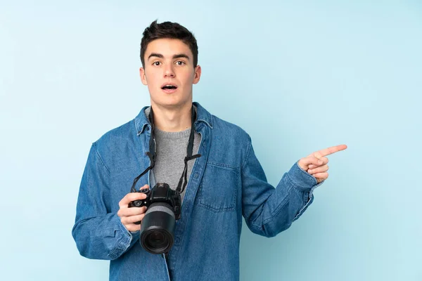 Teenager Photographer Man Isolated Blue Background Surprised Pointing Finger Side — Stock Photo, Image