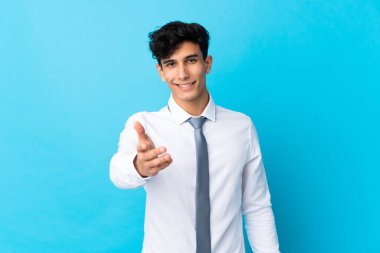 Arjantinli genç işadamı, iyi bir anlaşmadan sonra mavi arkaplan tokalaşması yaşadı.