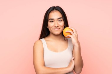 Elinde portakal tutan genç Hintli kadın.