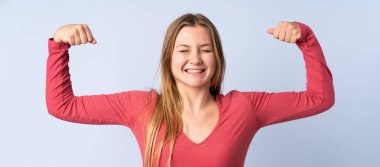 Genç Ukraynalı kız mavi arka planda izole edilmiş, güçlü bir jest yapıyor.