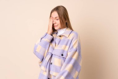 Genç Ukraynalı kız bej arka planda baş ağrısı ile izole edilmiş.
