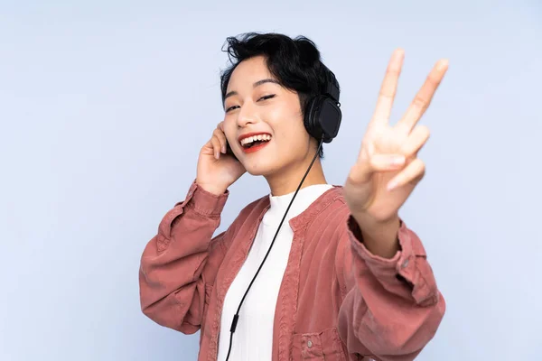 Joven Chica Asiática Sobre Aislado Fondo Azul Escuchar Música Cantar — Foto de Stock