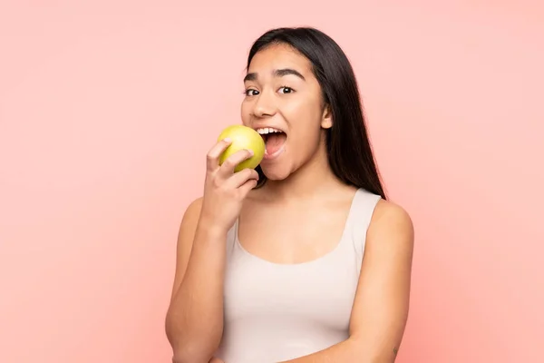 Jovem Indiana Isolada Fundo Rosa Comendo Uma Maçã — Fotografia de Stock