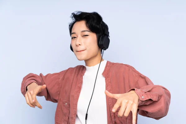 Joven Chica Asiática Sobre Fondo Azul Aislado Escuchando Música Bailando — Foto de Stock