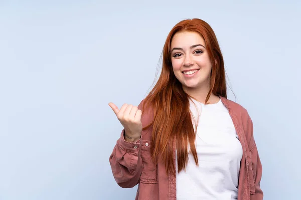 Rossa Adolescente Ragazza Isolato Sfondo Blu Che Punta Verso Lato — Foto Stock