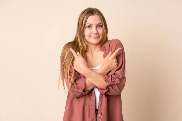 Teenager Ukrainian Girl Isolated Beige Background Pointing Laterals Having Doubts — Stock Photo, Image