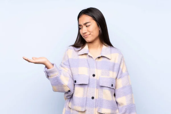 Mujer India Joven Aislada Sobre Fondo Azul Sosteniendo Copyspace Con —  Fotos de Stock