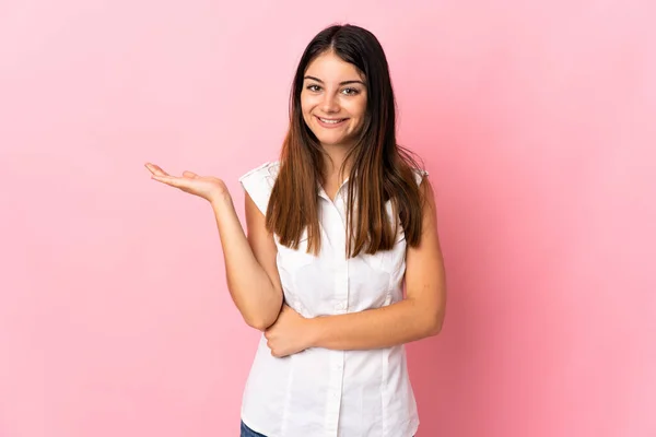 Ung Kaukasisk Kvinna Isolerad Rosa Bakgrund Håller Copyspace Imaginära Handflatan — Stockfoto