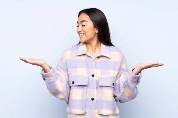 Mujer India Joven Aislada Sobre Fondo Azul Sosteniendo Copyspace Con —  Fotos de Stock