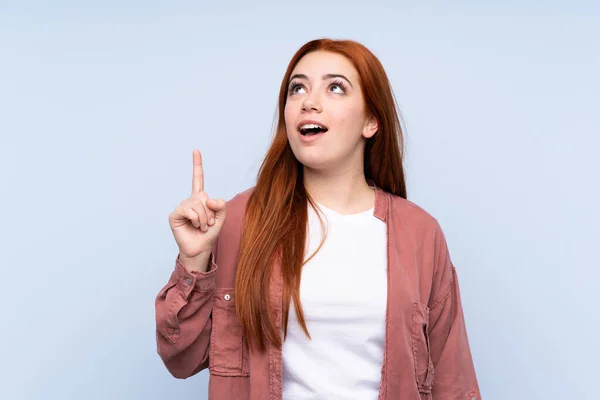 Ruiva Adolescente Menina Sobre Isolado Fundo Azul Apontando Para Cima — Fotografia de Stock