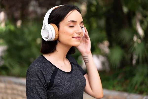 Νεαρή Καυκάσια Γυναίκα Που Ακούει Μουσική Υπαίθριο Χώρο Πάρκο — Φωτογραφία Αρχείου