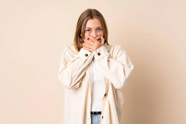 ティーンウクライナ人女の子絶縁上のベージュ背景カバー口と見ますザ側 — ストック写真