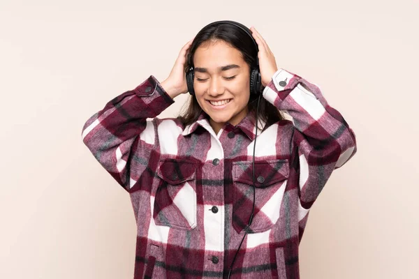 Mujer India Joven Aislada Sobre Fondo Beige Escuchando Música —  Fotos de Stock