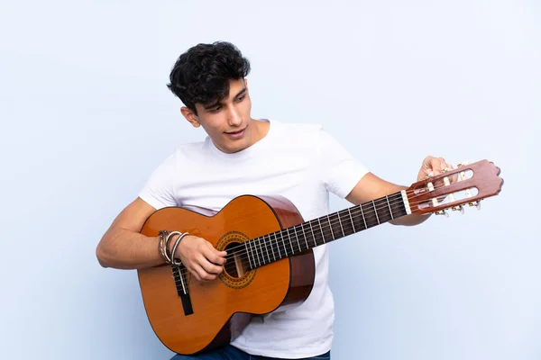 Jonge Argentijnse Man Met Gitaar Geïsoleerde Blauwe Achtergrond — Stockfoto