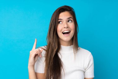 İzole edilmiş mavi arka planda genç bir kız parmak kaldırırken çözümü bulmayı amaçlıyor.