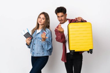 Mavi arka planda izole edilmiş bir bavul tutan gezgin çift bizimle gelmek için davet ediyor. Gelmene sevindim.