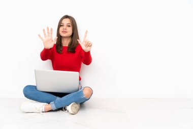 Polisle çalışan hassas kız beyaz arka planda izole edilmiş yediyi parmaklarıyla sayıyor