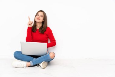 Polisle çalışan hassas kız beyaz arka planda izole edilmiş ve en iyinin işareti olarak parmağını kaldırıyor.