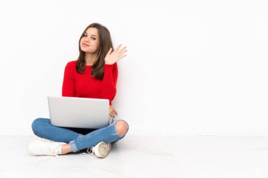 Polisle birlikte çalışan tenaager kız beyaz arkaplanda izole edilmiş mutlu bir ifadeyle selamlama yapıyor