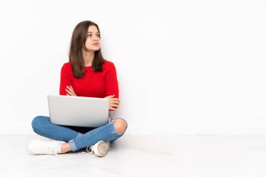 Bilgisayarla çalışan tenaager kız, beyaz arkaplanda yanal konumda izole edildi