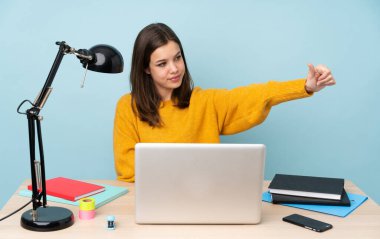 Öğrenci kız, mavi arka planda izole bir şekilde evinde ders çalışıyor.